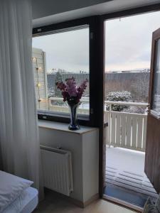 un jarrón de flores sentado en una mesa junto a una ventana en Winter holiday near Tallinn, en Viimsi