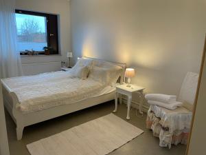 1 dormitorio con cama, ventana y silla en Winter holiday near Tallinn, en Viimsi