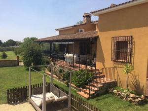 ein Haus mit einer Veranda und einer Treppe im Hof in der Unterkunft Casa rural Dalia in Sierra de Fuentes