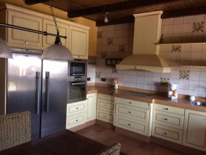 uma cozinha com armários brancos e um frigorífico de aço inoxidável em Casa rural Dalia em Sierra de Fuentes
