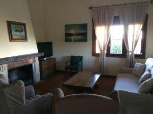 ein Wohnzimmer mit 2 Sofas und einem Kamin in der Unterkunft Casa rural Dalia in Sierra de Fuentes