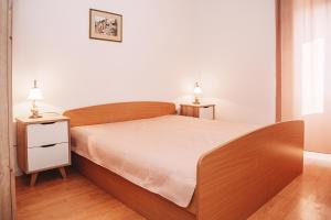 a bedroom with a bed and two lamps on two tables at Apartments Tončica in Božava