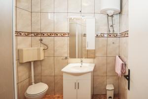 a small bathroom with a toilet and a sink at Apartments Tončica in Božava +13 photos