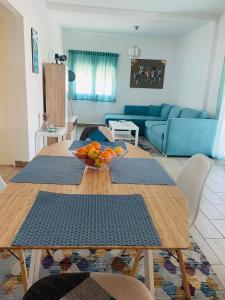 sala de estar con mesa y sofá azul en Villa ,,Sea Breeze,, - home by the sea, en Nea Anjíalos