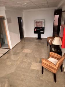 a living room with chairs and a television in a room at Hotel Las Tablas in Daimiel