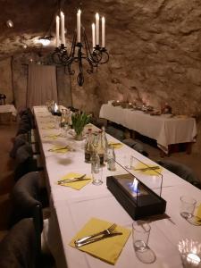una mesa larga en una habitación con mantel blanco en KvarnDammens Bed & Breakfast en Vetlanda