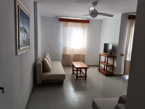 a living room with a couch and a television at Apartamentos Mary in Fuengirola