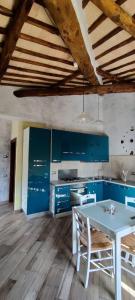 a kitchen with blue cabinets and a white table at casa dei gelsi in Bolsena