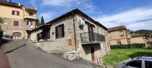 an old stone building with a balcony on a street at casa dei gelsi in Bolsena