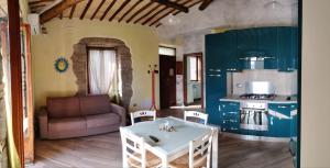 a living room with a white table and a kitchen at casa dei gelsi in Bolsena