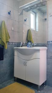 uma casa de banho com um lavatório e um espelho em Дионея em Belogradchik