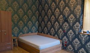 een klein bed in een slaapkamer met een muur bij Дионея in Belogradchik