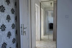a hallway with a glass door and a mirror at Apartament Słoneczny in Mrągowo
