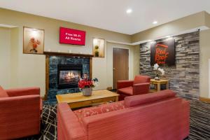 a lobby with two red chairs and a fireplace at Red Roof Inn South Bend - Mishawaka in South Bend
