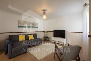 a living room with a couch and a tv at White House by AcasaDasCasas in Mafra