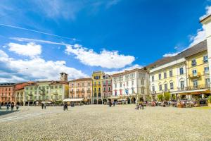 a city square with buildings and people walking around at Boutique Hotel Piazza Grande in Locarno