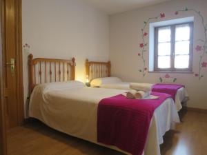 OizにあるPosada de Oitzの紫のシーツと窓が備わる客室のベッド2台