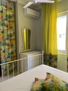 a bedroom with a bed and a mirror and curtains at Lefkas Marine Apartment in Lefkada