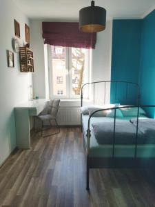 - une chambre avec un lit, un bureau et une fenêtre dans l'établissement Apartament na Starym Mieście, à Bolesławiec