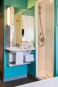 ein Bad mit einem Waschbecken und einem Spiegel in der Unterkunft Ibis budget Regensburg Ost in Regensburg