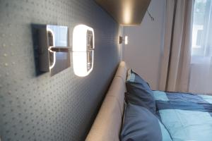 1 dormitorio con 1 cama y una luz en la pared en CRVN4 #terrace #freeparking en Budapest