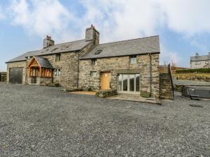 an old stone house with a gravel driveway at Hen Dy Craig Yr Ronwy in Bala
