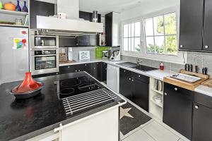 Una cocina con gabinetes negros y un horno de estufa. en Au 120 Maison Ville Albigeoise, en Albi