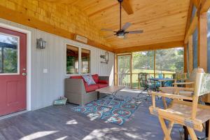 a porch with a red door and a red couch at Guntersville Lake Home with Deck and Covered Boat Slip in Scottsboro