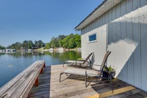 dos sillas y una mesa en un muelle sobre un cuerpo de agua en Guntersville Lake Home with Deck and Covered Boat Slip, en Scottsboro