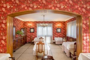 a dining room with tables and red wallpaper at Hotel Hontoria in Hontoria