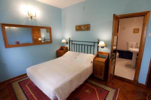 a bedroom with a bed and a mirror and a bathroom at Hotel Hontoria in Hontoria