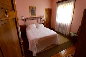 a bedroom with a bed with white sheets and a window at Hotel Hontoria in Hontoria