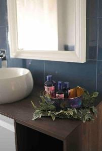 a bathroom counter with a bowl of toiletries on it at Vista Mare casa vacanze in Torre Annunziata