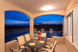 a patio with a table and chairs on a balcony at Ferienhaus Dalmatia bei Zadar in Zadar