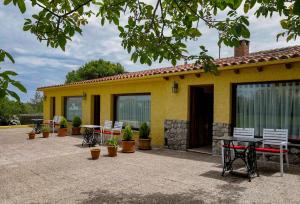 a yellow house with a patio with tables and chairs at Hotel Hontoria in Hontoria