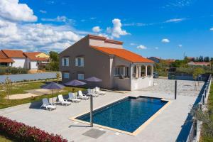 a villa with a swimming pool in front of a house at Ferienhaus Dalmatia bei Zadar in Zadar