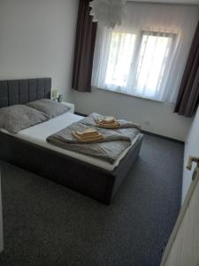 a bedroom with a bed with two towels on it at Apartamenty Słoneczna Przystań in Łeba