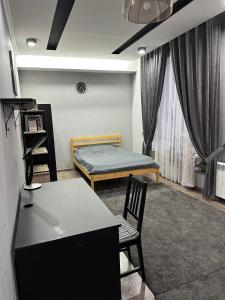 a room with a bed and a table and chairs at Ultra Hostel in Dushanbe