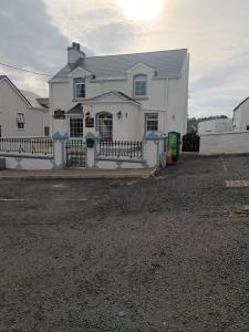 una casa bianca con una recinzione davanti di Ardhill House The Diamond, in the Heart of Ardara Town , F94 C7X9 a Ardara