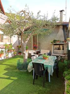 a patio with a table and chairs and a tree at Appartamento con vista Lago Casa Gaspar in Brenzone sul Garda