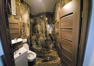 baño con aseo y pared de piedra en Racosim Residentials, en Seleuş