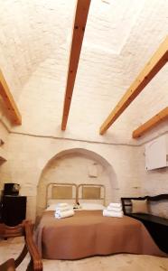 ein Schlafzimmer mit einem großen Bett im Dachgeschoss in der Unterkunft Lamia Pieranna in Cisternino