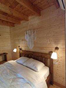 um quarto com uma cama numa parede de madeira em Zini House em Ein Zivan