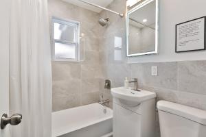 La salle de bains est pourvue de toilettes, d'un lavabo et d'un miroir. dans l'établissement FREE PARKING in Beautiful Lachine, à Montréal