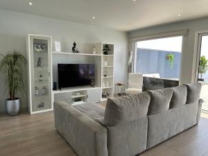 a living room with a large couch and a television at Casa Bela Vista in Venda do Atalhinho