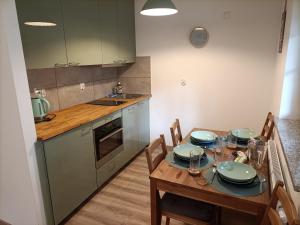 a kitchen with a table with plates on it at Apartament Green Hill in Szklarska Poręba
