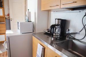 a small kitchen with a sink and a microwave at Erillinen ilmastoitu vierassviitti, Kokkola in Kokkola