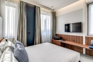 a hotel room with a bed and a flat screen tv at Sospeso Boutique Hotel in Milan