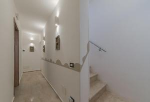 un corridoio con pareti bianche e scale in una casa di Sisidda rooms a San Vito lo Capo Altre 34 foto
