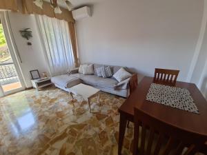 uma sala de estar com um sofá e uma mesa em Turchino Apartment & Terrazza della Luisa by PortofinoVacanze em Santa Margherita Ligure